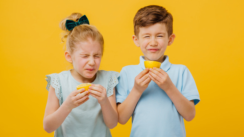 kids eating sour lemon