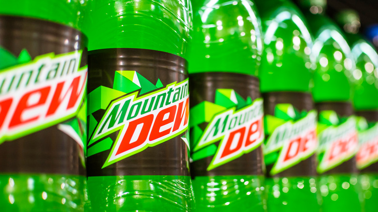 Rows of bottles of Mountain Dew on a shelf 