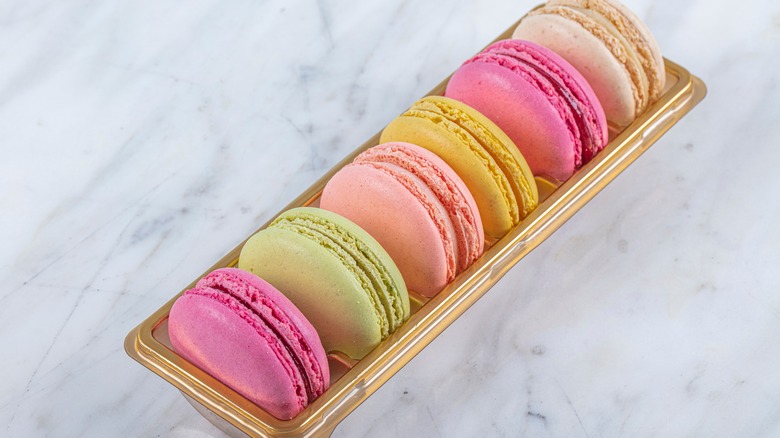 box of colorful macarons on a marble table