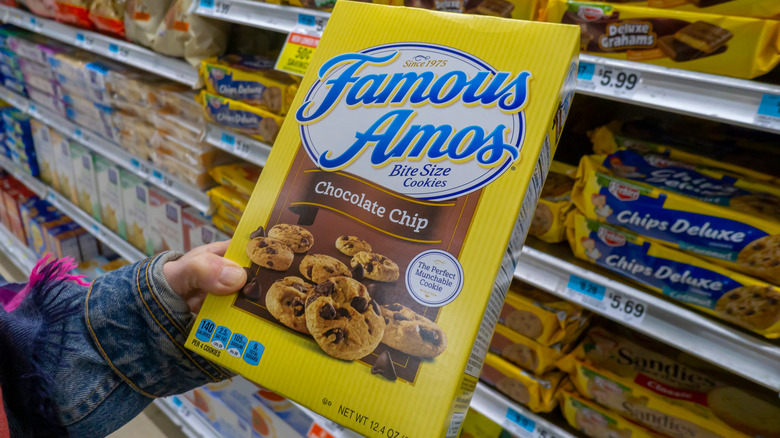 Person holding box of Famous Amos at grocery store
