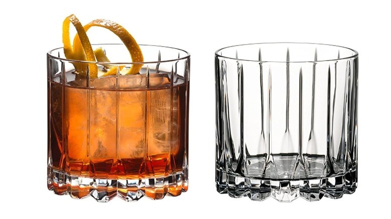 2 rocks glasses, one with liquid and a citrus rind