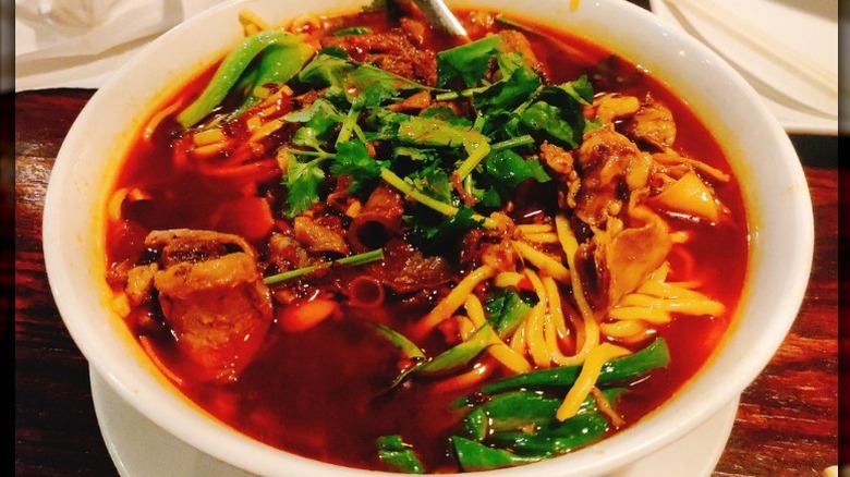 A white bowl of beef noodles