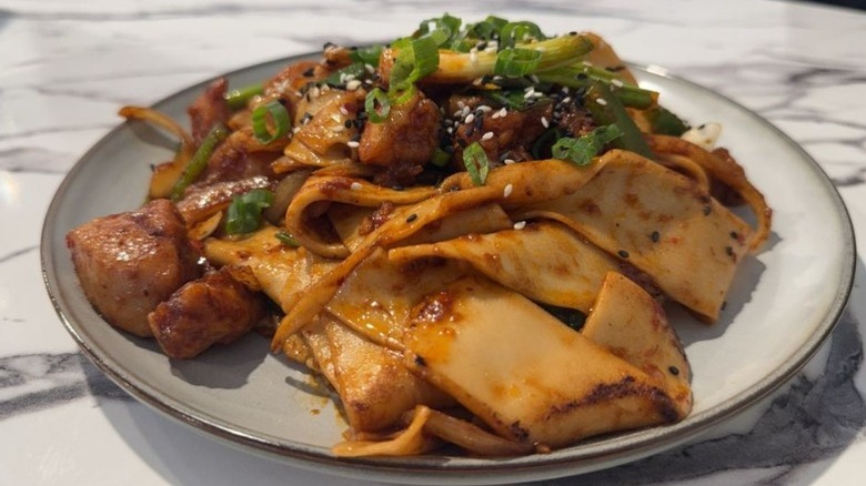 A traditional Uyghur noodle dish on a white plate