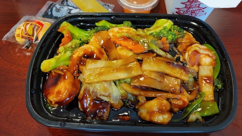 Shrimp with vegetables and sauce in a to-go container