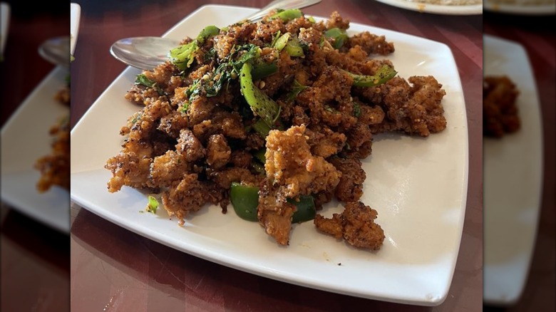 Coffee popcorn chicken on a square white plate