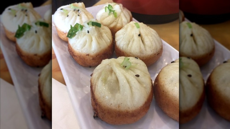 Crispy Bottom Pork Baos on a rectangular white plate