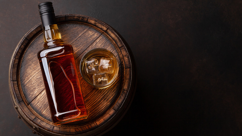 Bottle of Bourbon on top of a barrel 