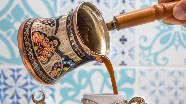 Turkish coffee being poured from a Turkish coffee pot