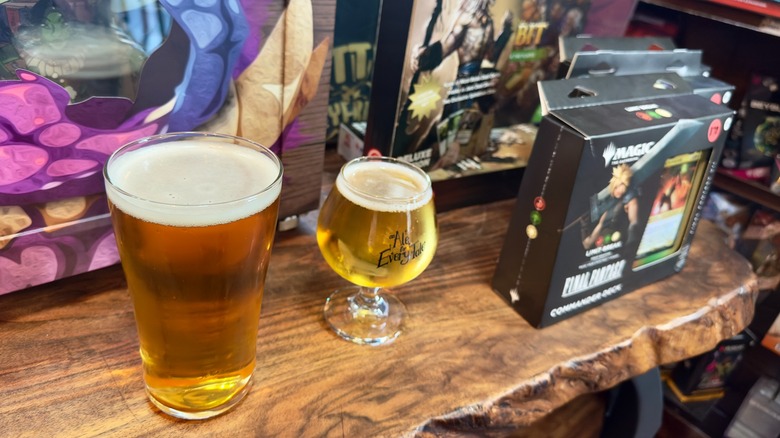 Beers on a wooden table next to Magic: The Gathering cards