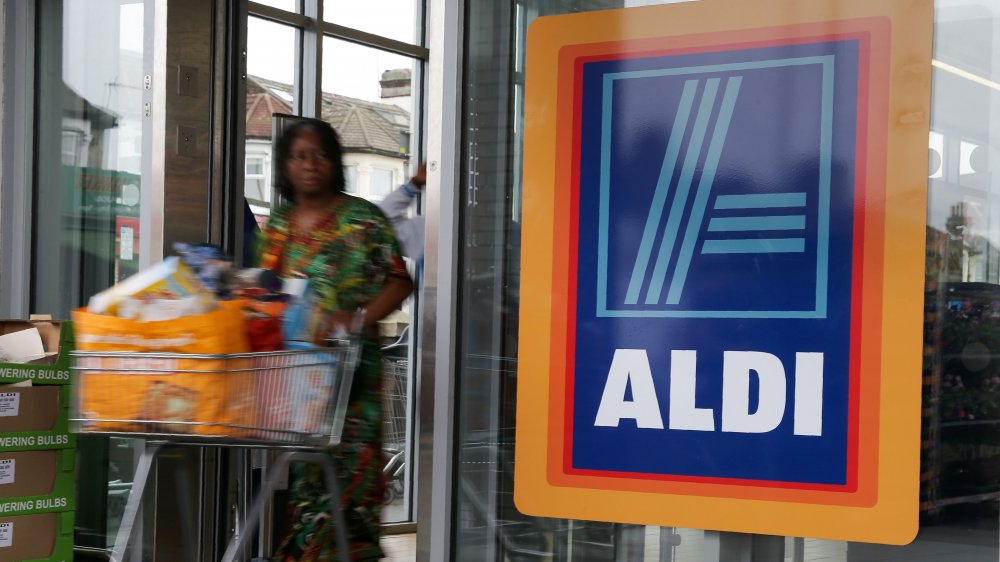 woman pushing a cart out of an Aldi store