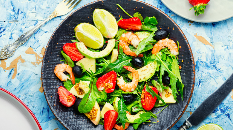 Salad with shrimp strawberries olives and lemons