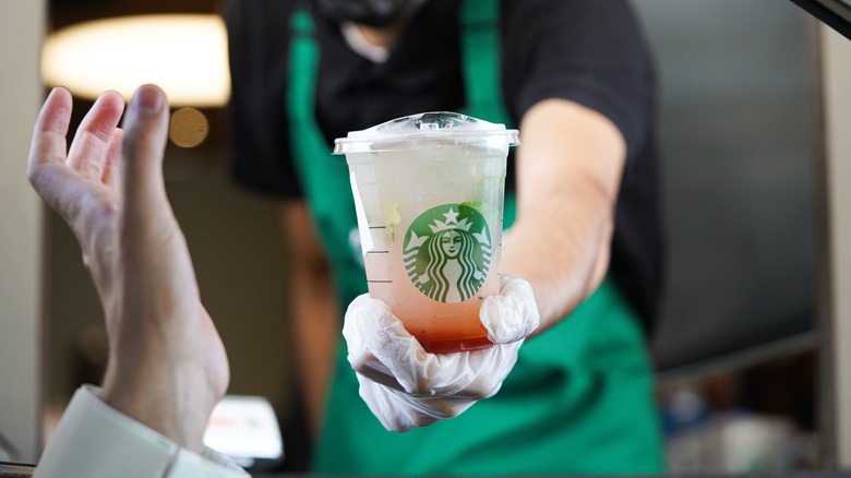 Starbucks barista handing over drink