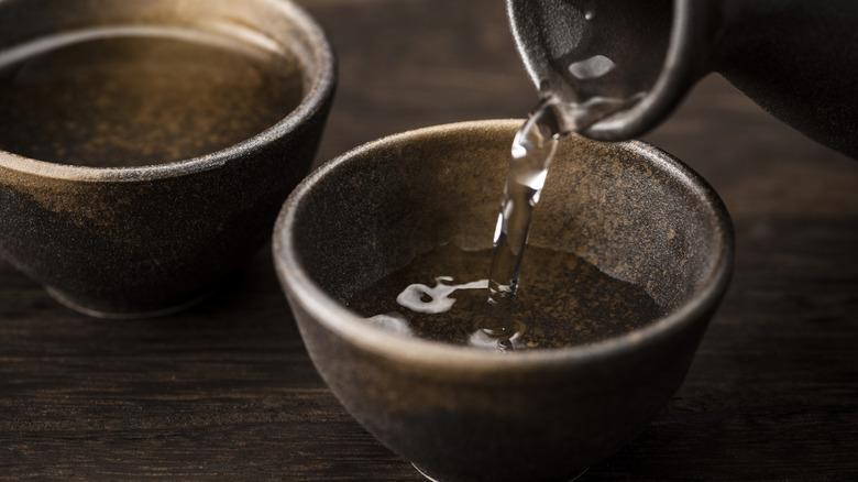 Pouring sake into small ceramic cups
