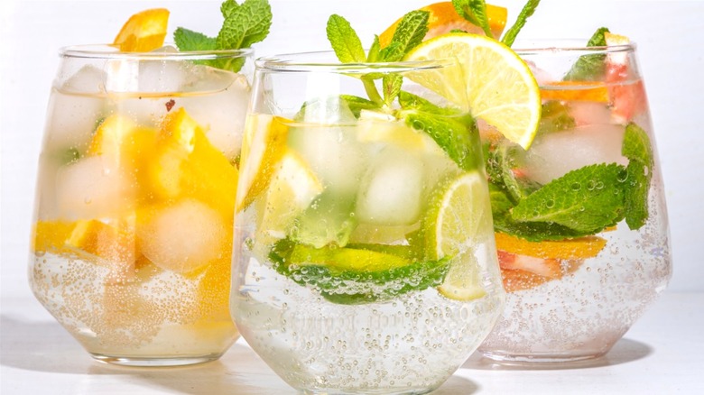 water in glasses with ice fruit and leaves