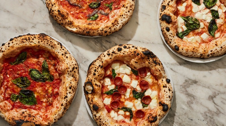overhead view of four pizzas from Una Pizza Napoletana on table