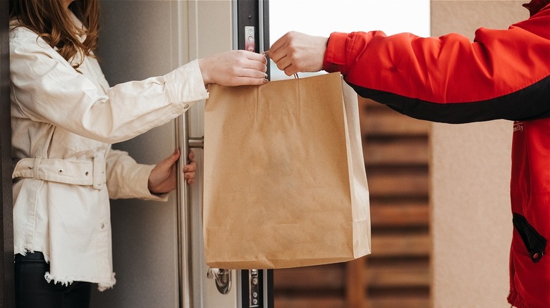 Delivery driver handing someone takeout
