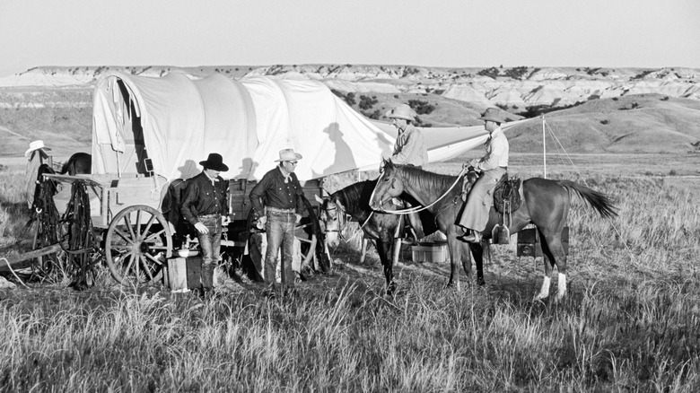 Cowboys gather around a chuckwgon