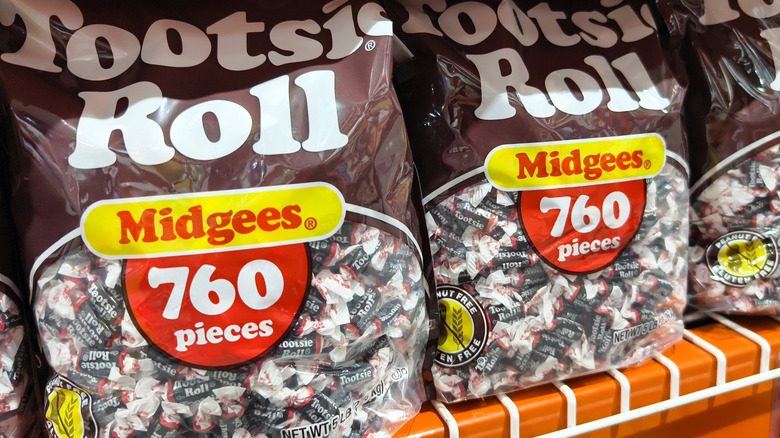 Two bags of mini-Tootsie Rolls on a display shelf.