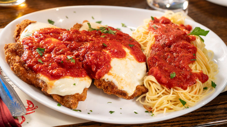 Veal parmesan on plate with pasta