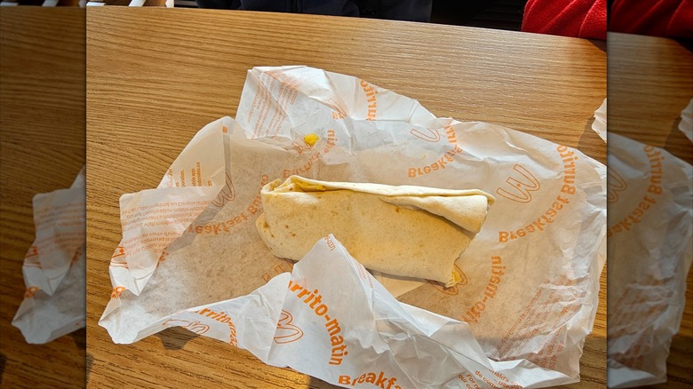 Unwrapped McDonald's breakfast burrito on table