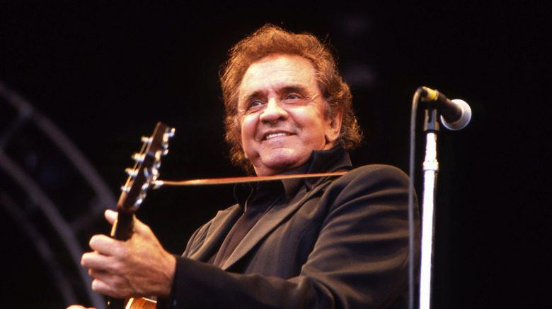 Johnny Cash smiling with guitar