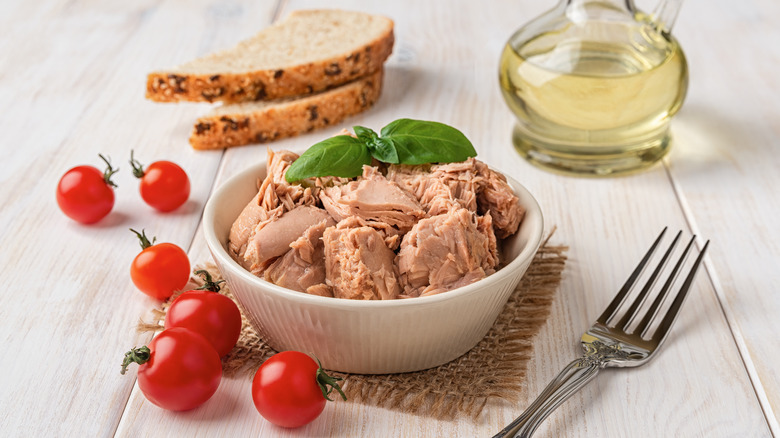 Tuna meat in a bowl with basil and tomatoes