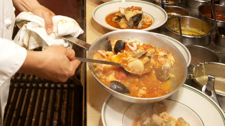 Chef plating seafood stew at Tadich Grill