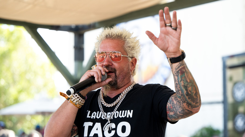 Guy Fieri at an event speaking into a microphone