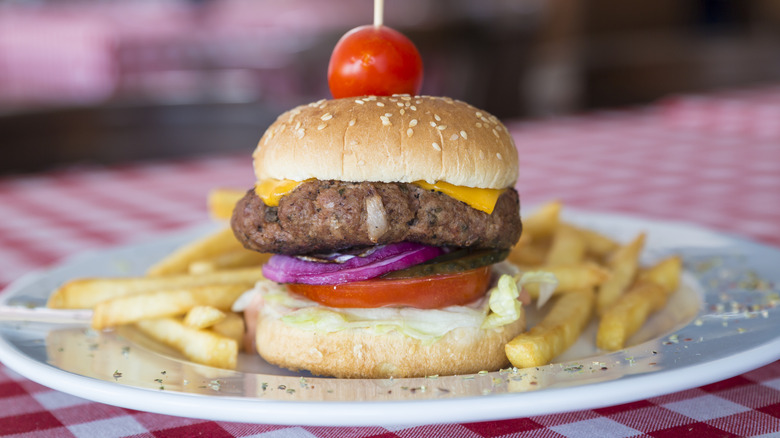 A retro hamburger with a cherry tomato on top
