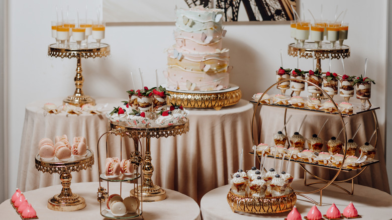 Draped tables stacked with a variety of desserts