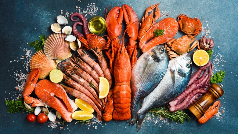 A variety of seafood with coarse salt, shaker, and lemon wedges