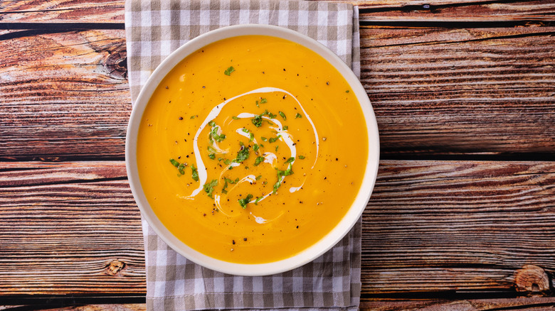 Pumpkin soup in a bowl placed on a wooden table