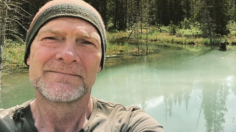 Les Stroud taking a selfie by lake