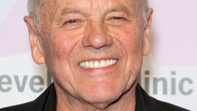 A smiling Wolfgang Puck against a pastel background