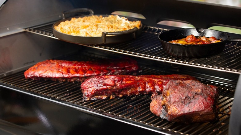 Various foods cooking on two-tier grill