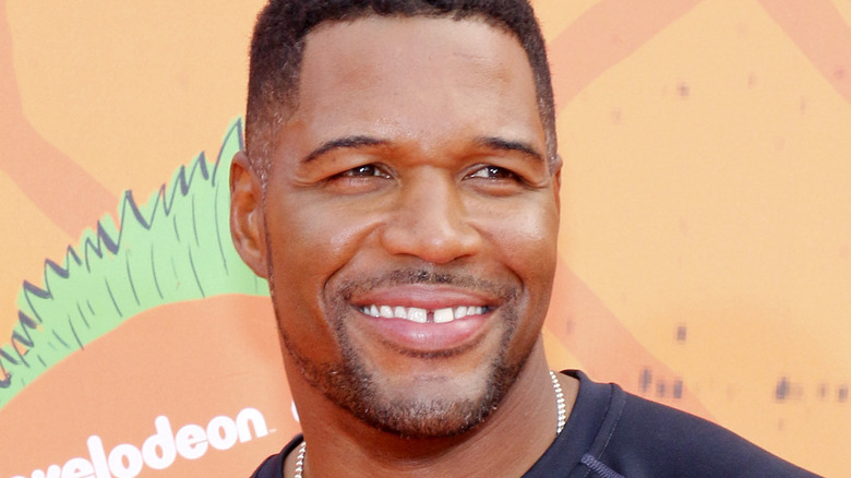 Michael Strahan smiles in black shirt