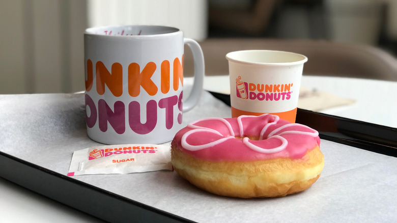 Pink donut and white coffee cups