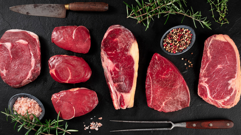 Different cuts of steak with vintage carving knife utensils