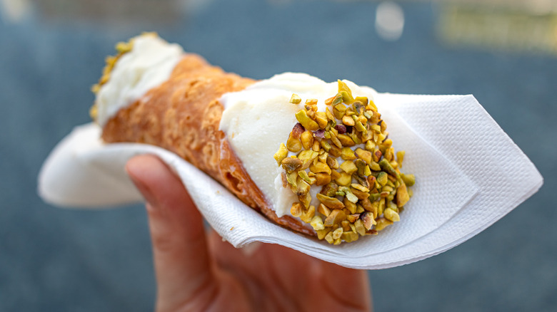 Hand holding a cannoli