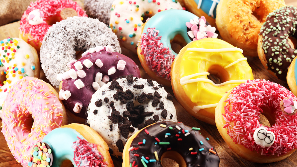 Assorted and colorful donuts on a wooden board