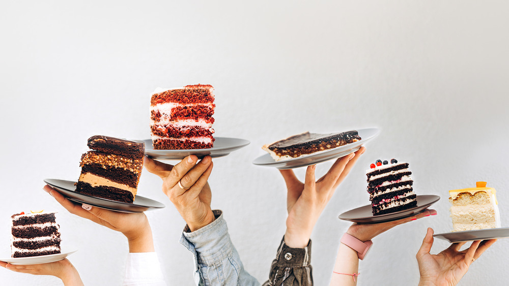 Hands holding up slices of cake