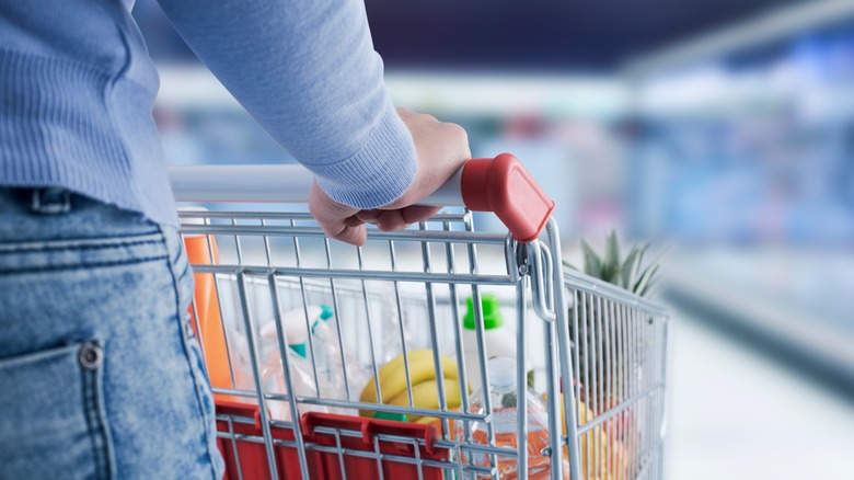 woman pushing full grocery cart