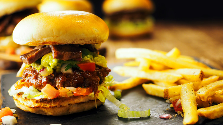 A slider and fries with three more sliders in the background