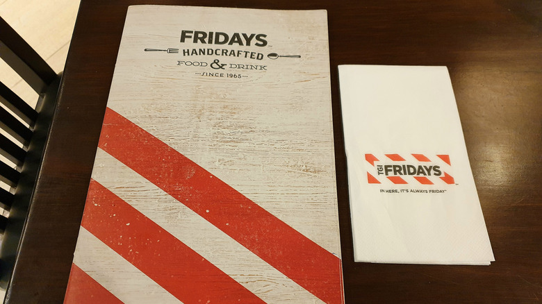 TGI Fridays menu on a restaurant table with a napkin beside it