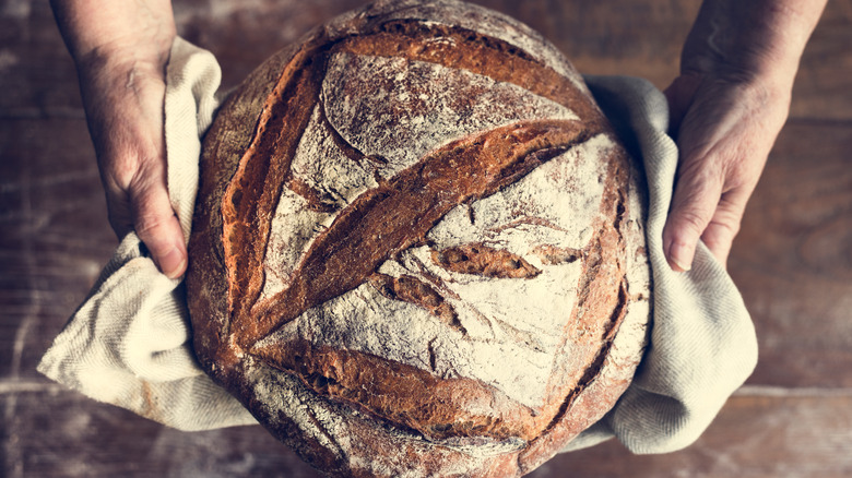 Baker holding sourdough bread