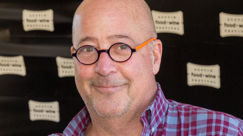 Andrew Zimmern wearing a plaid shirt and glasses