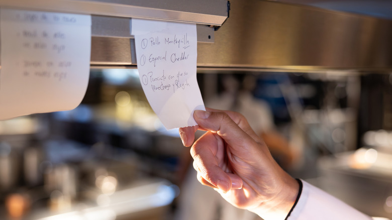 Someone looking at a restaurant order ticket