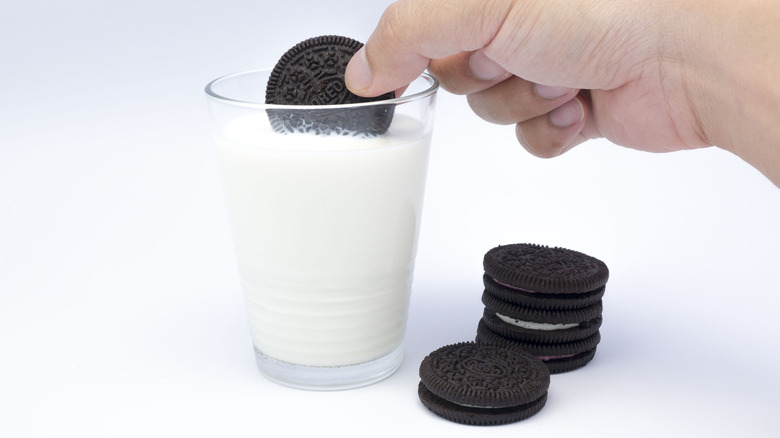 Person dunking Oreos in a glass of milk