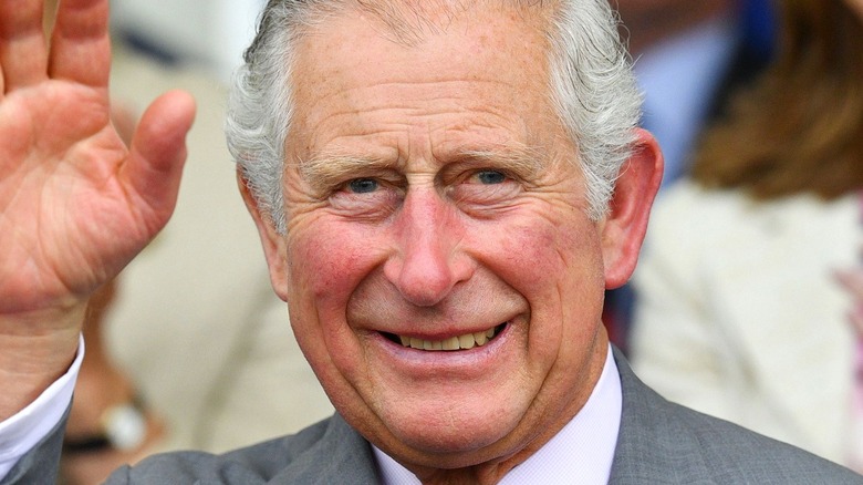 King Charles III smiling and waving