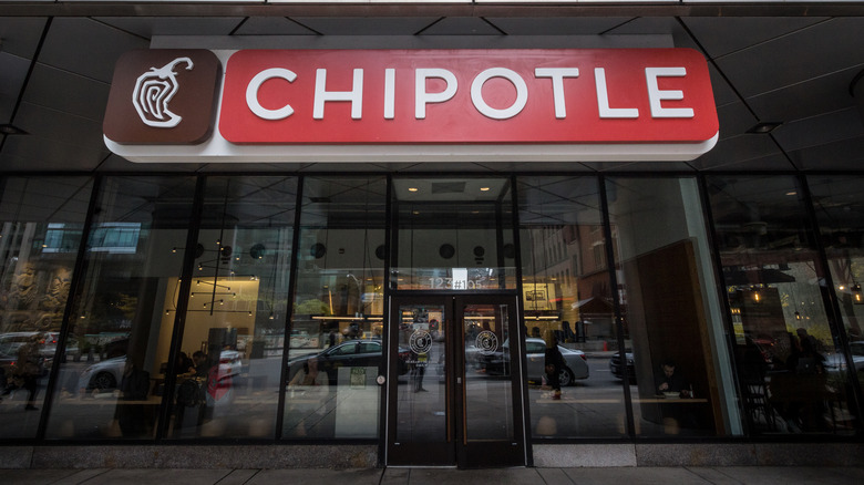 Red Chipotle sign on exterior of glass building